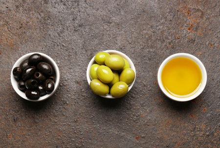 Bowls with ripe olives and oil on grunge backgroundの写真素材