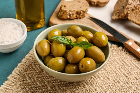 Bowl with ripe olives on green backgroundの写真素材
