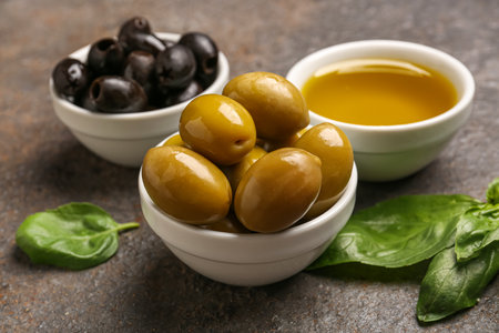 Bowls with ripe olives and oil on grunge backgroundの写真素材