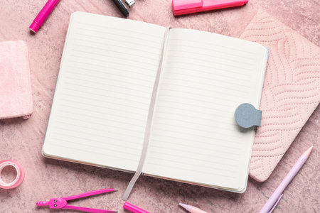 Notebooks with different stationery on grunge pink backgroundの写真素材
