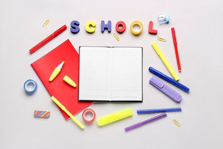 Notebooks with different stationery and word SCHOOL on white backgroundの写真素材