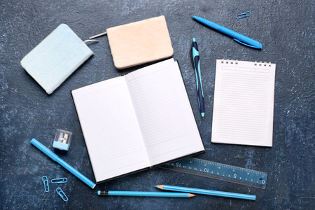 Notebooks with different stationery on grunge dark blue backgroundの写真素材