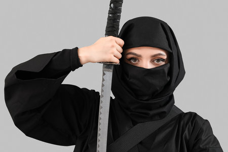 Female ninja with sword on gray backgroundの写真素材