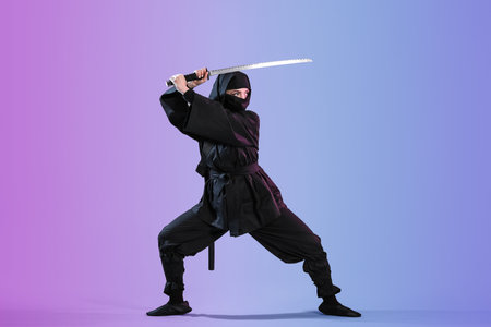 Female ninja with sword on color backgroundの写真素材