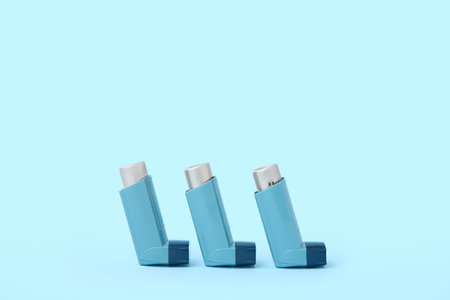 Asthma inhalers on blue background