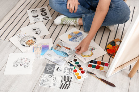 Mature female artist with many sketches in workshop