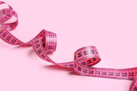 Measuring tape on pink background, closeupの写真素材