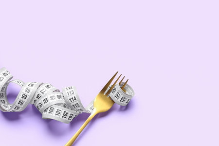 Fork with measuring tape on lilac background