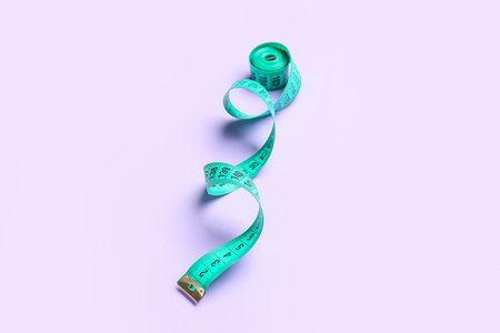 Measuring tape on lilac backgroundの写真素材