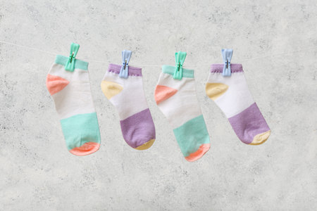 Cotton socks hanging on rope against light backgroundの写真素材