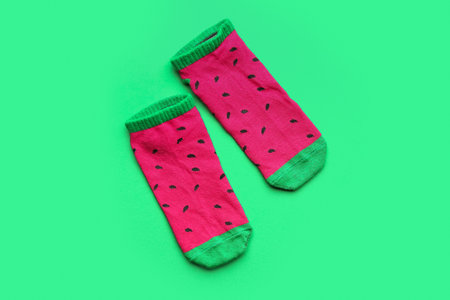 Pair of colorful cotton socks on green backgroundの写真素材