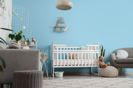 Interior of stylish bedroom with baby crib, sofa and armchairの写真素材