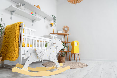 Stylish interior of children's room with baby bed and rocking horseの写真素材