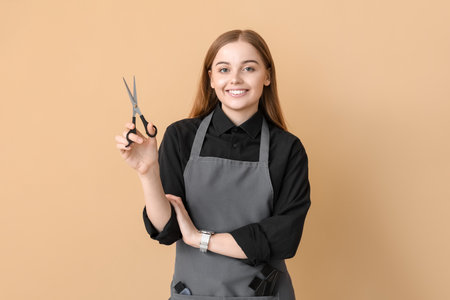 Female hairdresser with scissors on gray backgroundの写真素材