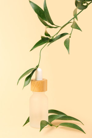 Bottle of cosmetic oil with eucalyptus twigs on beige backgroundの写真素材