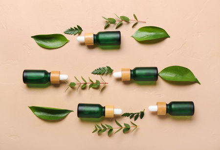 Bottles of cosmetic oil with plant twigs on beige backgroundの写真素材