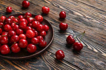Plate with sweet cherry on wooden backgroundの写真素材