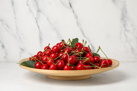 Plate with sweet cherry on white background