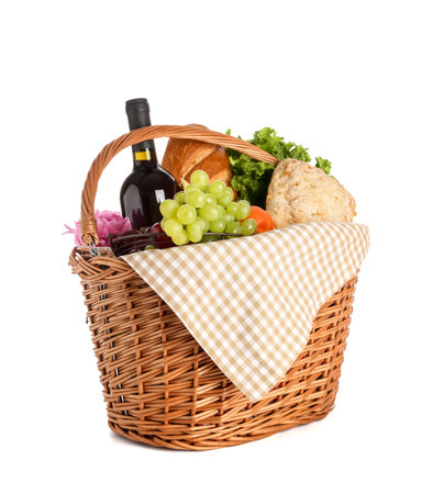 Wicker basket with tasty food for picnic and wine on white backgroundの写真素材