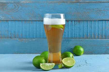 Glass of cold beer with lime on tableの写真素材