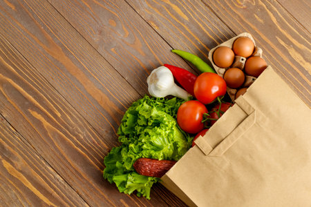 Paper bag with different products on wooden backgroundの写真素材