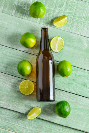 Bottle of cold beer with lime on wooden backgroundの写真素材