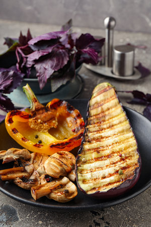 Plate with grilled vegetables and basil on gray backgroundの写真素材