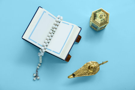 Koran with tasbih, Aladdin lamp, and fanous on color background. islamic new year celebrationの写真素材