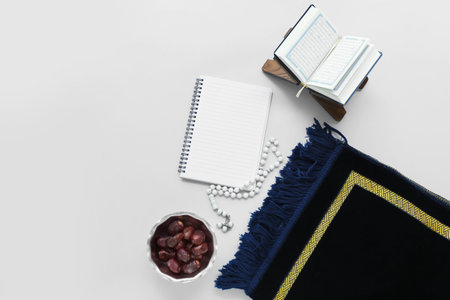 Blank notebook, Koran, mat and tasbih on light background. islamic new year celebrationの写真素材