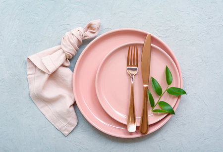 Beautiful table setting with clean plate, cutlery and plant branch on gray tableの写真素材