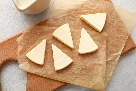 Board with triangles of tasty processed cheese and milk on light background, closeupの写真素材