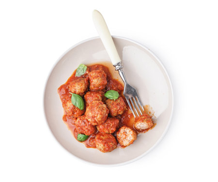 Plate of tasty meat balls with tomato sauce and basil on white backgroundの写真素材