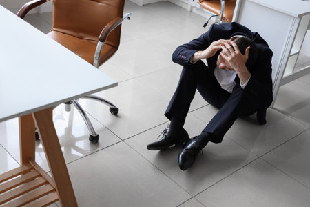 Young businessman having panic attack in officeの写真素材