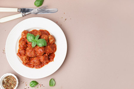 Plate of tasty meat balls with sauce on beige backgroundの写真素材