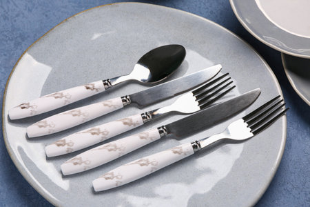 Clean with set of cutlery on gray grunge table, closeup