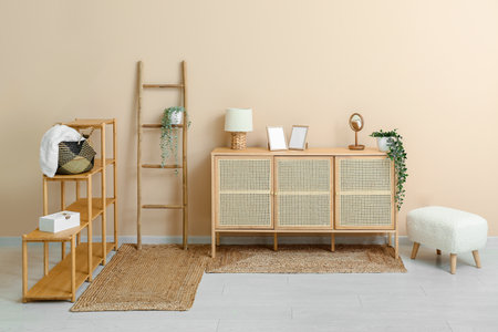 Stylish interior of living room with shelving unit, ladder, drawers and wicker rugsの写真素材