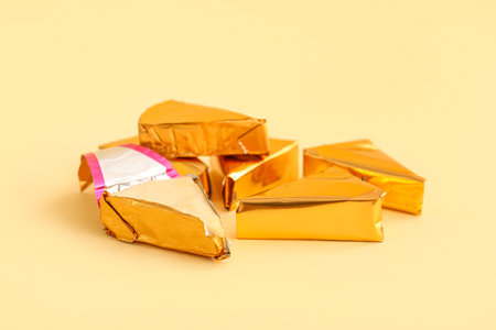 Triangles of tasty processed cheese on yellow backgroundの写真素材