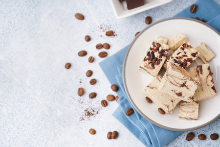 Plate with pieces of tasty marble halva on light backgroundの写真素材