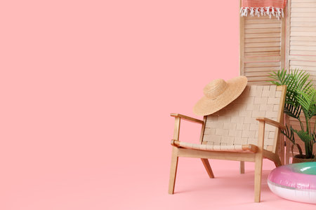 Chair with inflatable ring, wicker hat and folding screen on pink background. travel conceptの写真素材