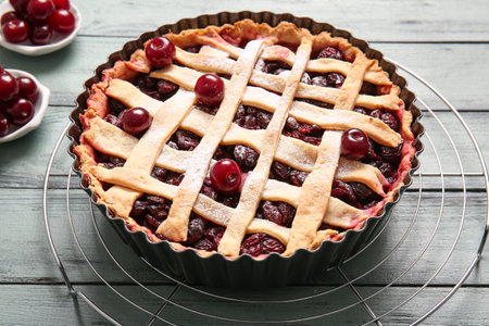 Baking dish with tasty cherry pie on blue wooden backgroundの写真素材