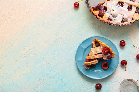 Baking dish with tasty cherry pie and plate of piece on blue backgroundの写真素材