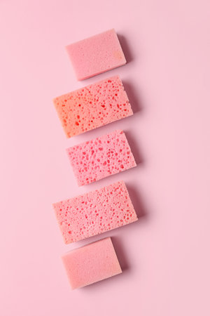 Row of different sponges on pink backgroundの写真素材