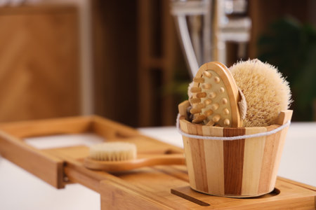 Bucket with massage brushes on stand in bathroom, closeupの写真素材