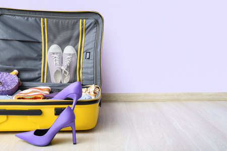 Suitcase with clothes, beach accessories, passport and ticket on floor. travel concept