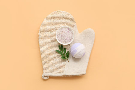 Massage glove, sea salt and bath bomb on color backgroundの写真素材