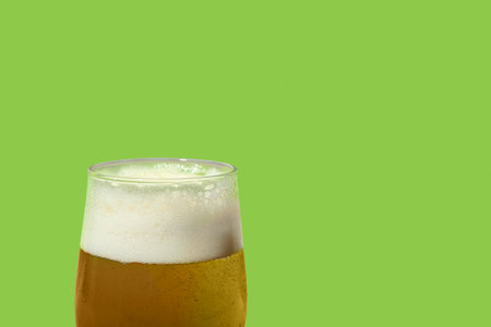 Glass of cold beer on green background, closeupの写真素材