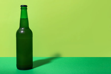 Bottle of cold beer on green backgroundの写真素材