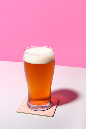 Glass of cold beer on color backgroundの写真素材