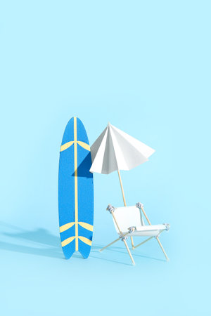 Creative composition with miniature surfboard, deckchair and umbrella on blue backgroundの写真素材