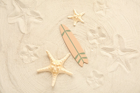 Mini surfboard with starfish on sandの写真素材